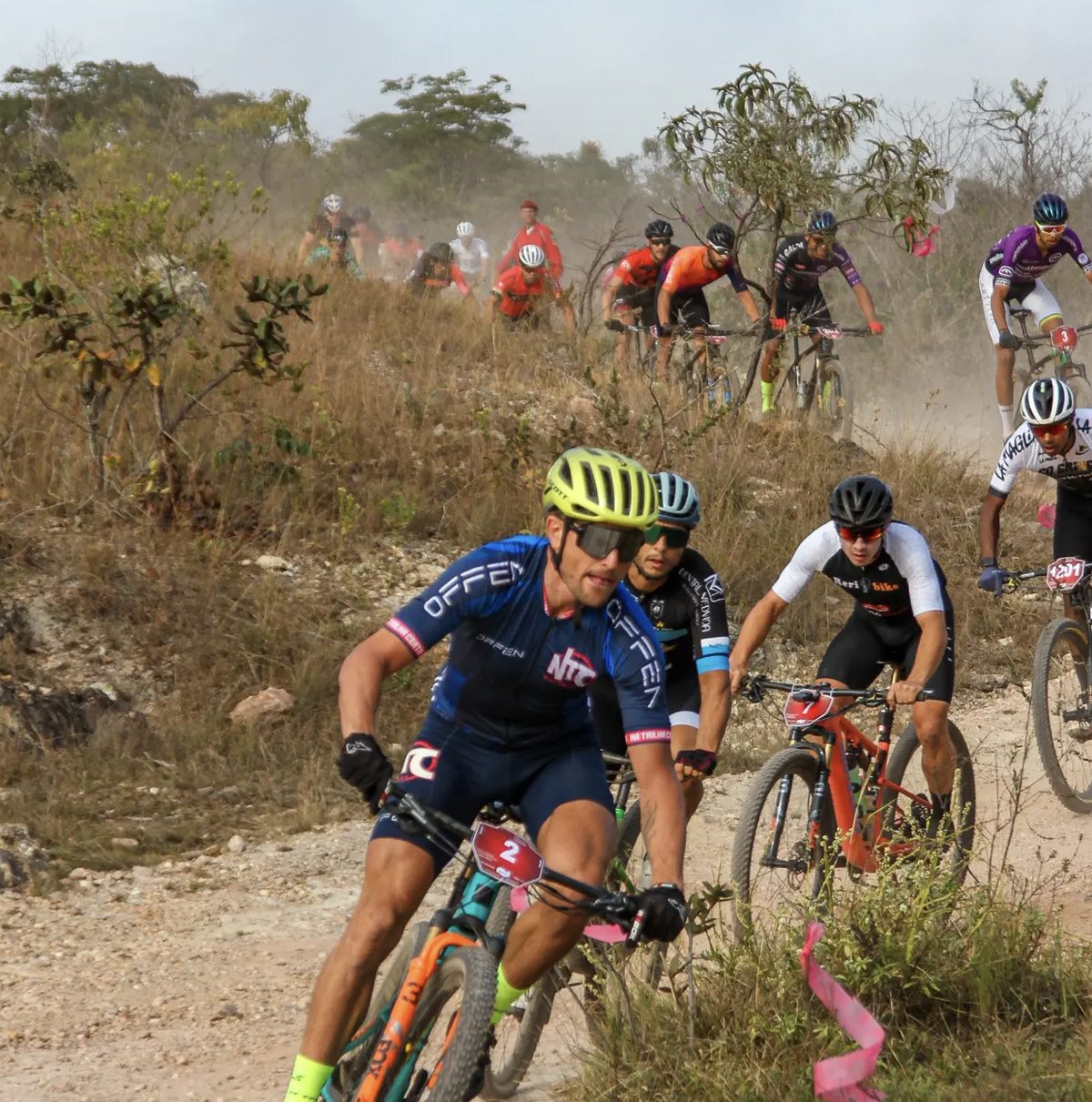 Lukas Kaufmann com o número 2 à frente de um grupo de ciclistas numa trilha de terra